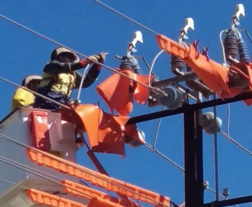 2 people in safety gear in a boom lift working on power lines for UET40422 Certificate III in ESI Network Systems